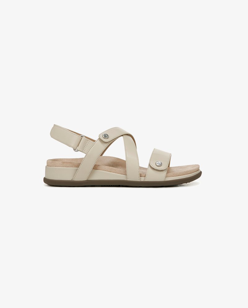 Sandalo beige con una soletta testurizzata, cinturini regolabili e accenti metallici. Presenta una suola piatta con un'intersuola imbottita per il comfort.