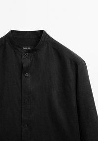 Zwarte linnen shirt met een bandkraag, frontsluiting met knopen en een licht gestructureerde stof. Heeft een minimalistisch ontwerp en gestructureerde schouders.