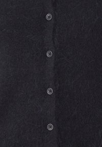 Cardigã azul escuro feito de um tecido suave e texturizado com uma aparência felpuda. Apresenta seis botões pretos na parte da frente.