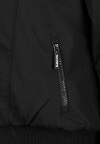 Czarna kurtka bomberka z boczną kieszenią na zamek z teksturowanym uchwytem i ściągaczami przy rękawach. Gładka tkanina i smukły design.