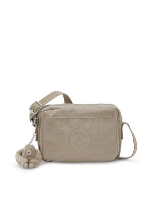 Sac bandoulière beige en tissu texturé, fermeture éclair, et un porte-clés singe peluche détachable. Présente un logo embossé à l'avant.