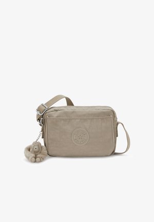 Beige Umhängetasche aus strukturiertem Stoff mit Reißverschluss und abnehmbarem, pelzigem Affenschlüsselanhänger. Auf der Vorderseite ist ein geprägt Logo zu sehen.