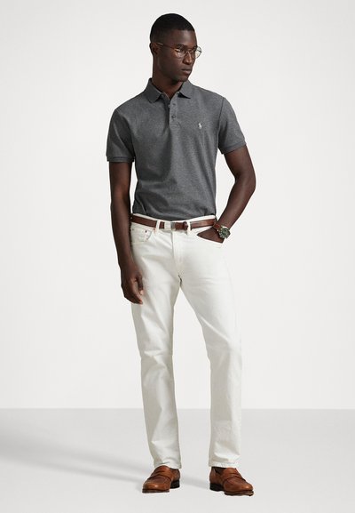 Γκρι πόλο μπλούζα με κοντά μανίκια, λευκό τζιν παντελόνι, καφέ ζώνη και καφέ loafers. Συμπληρωμένο με στρογγυλά γυαλιά και ρολόι.