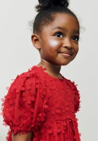 Rotes Kleid aus transparenter Stoff mit 3D-Blütenapplikationen, Puffärmeln und einer gerafften Taille. Glatte Textur mit floralen Akzenten.