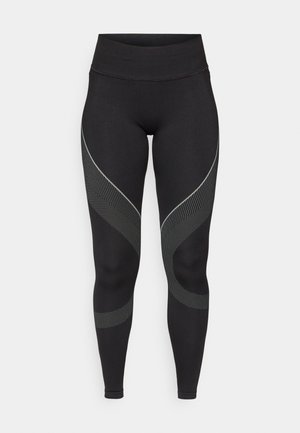 Black leggings with a high waistband, featuring a wavy grey and dotted pattern along the sides. Made of stretchy fabric for comfort.