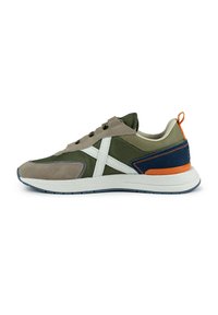 Baskets vertes et beige avec un logo blanc, en matériaux en suède et en maille, avec un col rembourré, des accents orange et une semelle en caoutchouc texturé.
