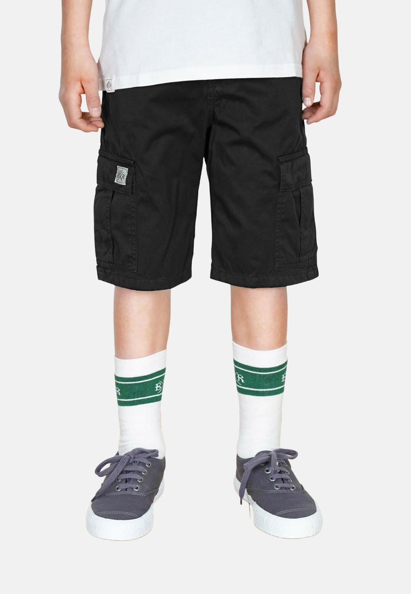 Svarta cargo shorts med sidofickor, tyg av bomullsblandning, tillsammans med vita strumpor med gröna ränder, och gråCanvas sneakers.