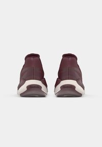 Pantofi sport bordo cu un material superior neted, guler căptușit și talpă texturată. Prezintă o talpă intermediară albă și logo-ul Reebok la călcâi.