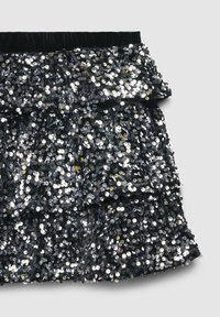 Gonna nera con paillettes, caratterizzata da strati arricciati, con una morbida vita in velluto e una superficie lucida e testurizzata decorata con paillettes riflettenti.