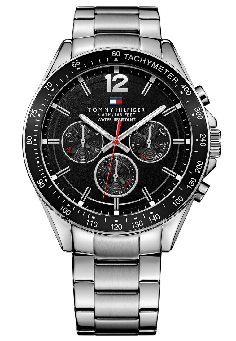 Reloj de acero inoxidable con esfera negra, acentos plateados, tres subesferas, taquímetro y un destacado número 12. Resistente al agua, con el logotipo de la marca.