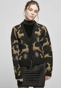 Black knitted cardigan featuring a gold reindeer pattern and white snowflakes, with a v-neckline and five black buttons.