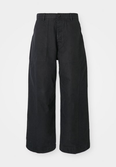 Black wide-leg trousers made of canvas material with a button closure, featuring two front pockets and a relaxed fit.
