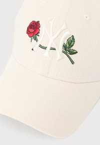 Krém színű kordbársony sapka hímzett piros rózsával és zöld levelekkel, mellettük egy fehér NY logóval. Görbített karimával és varrási részlettel rendelkezik.