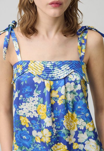 Top floreale blu con fiori gialli e bianchi, dotato di scollatura plissettata e spalline regolabili.