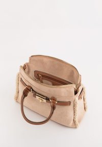 Bolso beige de ante con un acento texturizado tipo piel en los costados. Asas y detalles de cuero marrón, con una cremallera y cierre dorados.