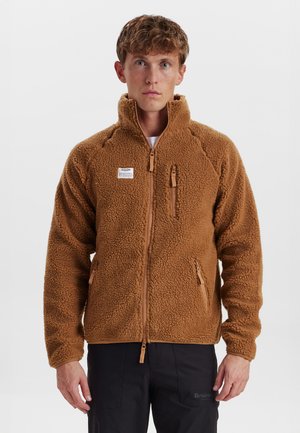 Brown fleece jacket with a high collar, zippered front, and two zippered pockets. Features a soft, textured fabric with a snug fit.