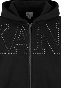 Black hooded zip-up sweatshirt featuring silver stud embellishments forming the letters "KAN" across the front, with a smooth fabric texture.