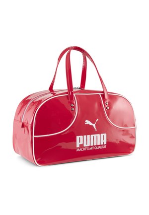 Rød patentlæder taske med afrundet form, hvid piping og to håndtag. Har fremtrædende hvid "PUMA" logo og tekstdetalje.