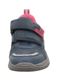 Baskets en daim gris et mesh avec des accents roses, deux bandes Velcro et une semelle en caoutchouc texturée. Présente un logo sur le côté et une languette au dos.