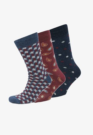 Drei Paar Socken: eines mit einem karierten Muster in Marineblau und Rot, eines in Kastanienbraun mit Paisleymuster und eines in Marineblau mit weißen und roten Pünktchen.