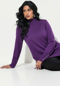 Maglione viola lavorato a maglia con un collo alto, polsini a costine e bottoni decorativi sulle maniche. Morbida consistenza e vestibilità comoda.