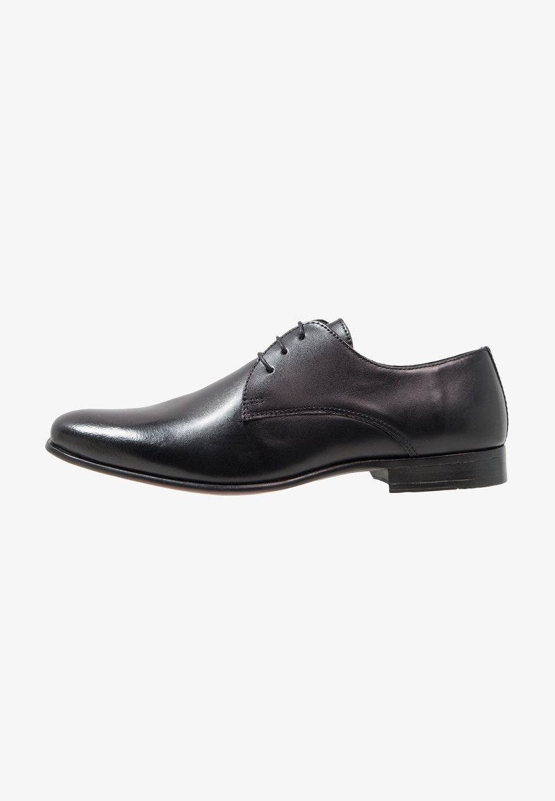 Chaussure oxford pour homme en cuir noir avec fermeture à lacets, finition lisse et petit talon empilé, présentée en profil latéral sur fond blanc.