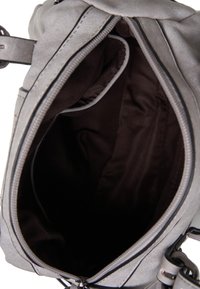 Grijze suède handtas met een bovenste ritssluiting, voorzien van een donkerbruine stoffen voering en een ruime binnenkant. Geen opmerkelijke patronen of accenten.