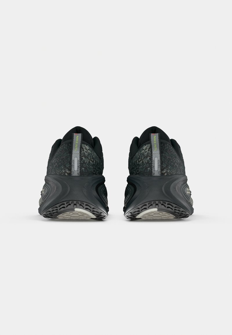 Pair of black and grey running shoes shown from the rear with textured soles and pull tabs labeled "NIKE INTL."
