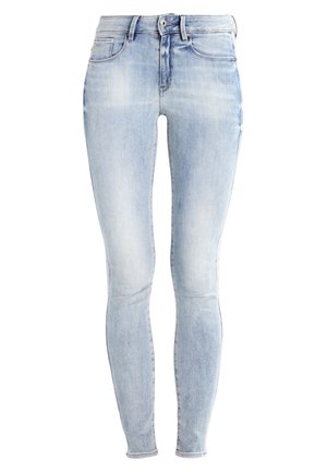 Light blue denim skinny jeans with a faded finish, five-pocket design, and a zipper fly. Features a seamless waistband and slim fit.