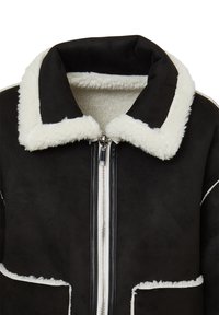 Veste en shearling noire avec un col et des finitions en polaire blanche, dotée d'une fermeture éclair à l'avant et de deux grandes poches. Texture douce et détails contrastants.