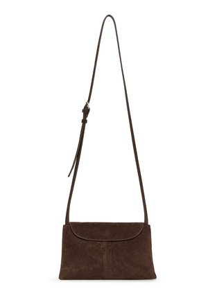 Bolso bandolera de ante marrón oscuro con una solapa frontal y una correa delgada ajustable colgando verticalmente sobre un fondo blanco.