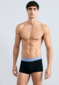 Čierne boxerské nohavičky s svetlomodrým pásom s logom "Calvin Klein", priliehavý strih, vyrobené z mäkkej a elastickej látky.