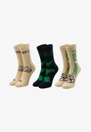 Three pairs of crew socks with Jurassic World designs: beige with "T-REX" text, black with green dinosaur silhouettes, and beige with green "Jurassic World" text.