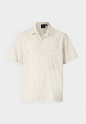 Short-sleeve cream shirt with embroidered floral patterns and button front. Slightly relaxed fit, made of soft cotton fabric.