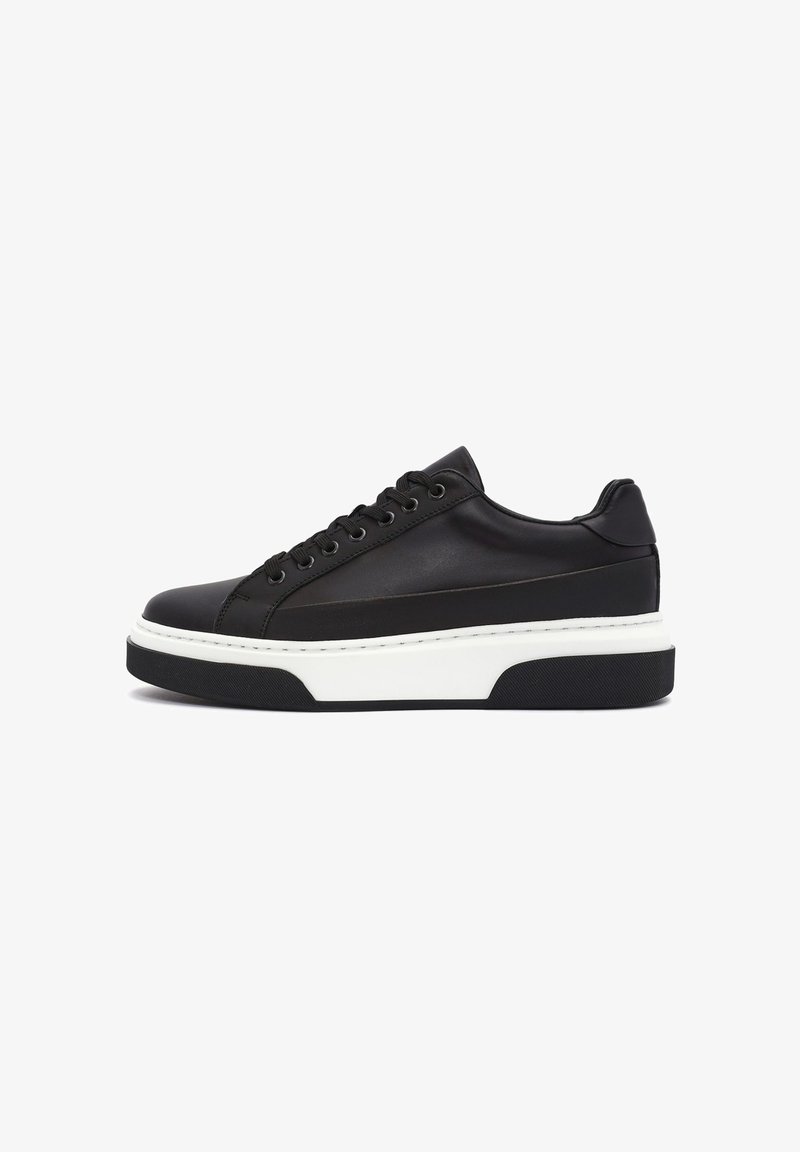 Czarne skórzane sneakersy z okrągłym noskiem, płaską białą podeszwą środkową i teksturowaną gumową podeszwą zewnętrzną. Wyróżniają się sześcioma oczkami i akcentami w postaci przeszyć.