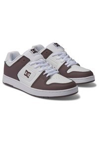White and brown athletic shoes, featuring a padded collar, lace-up front, and a rubber sole. DC logo displayed on the side and tongue.
