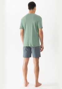 Light green short-sleeve t-shirt paired with patterned dark blue shorts featuring small white square designs.