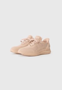 Baskets de sport beige clair avec une tige en maille, design à lacets et semelle en caoutchouc texturée. Présente des détails subtils sur les côtés.