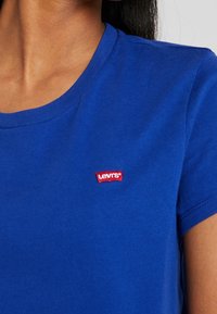 Konungsblå bomull t-shirt med kortärmar och rund halsringning, med en liten röd Levi's logotyp patch på vänster bröstområde.
