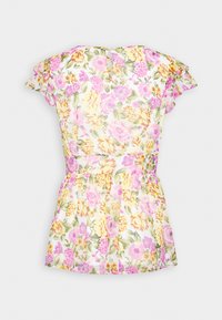 Blouse courte à motifs floraux roses, jaunes et verts, avec des manches flottantes et une taille cintrée.