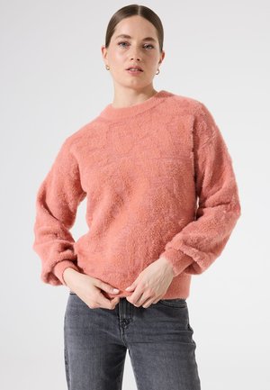 Pull rose, doux et en peluche avec un col rond et de longues manches légèrement bouffantes. La texture est douce et moelleuse, avec un motif subtil.