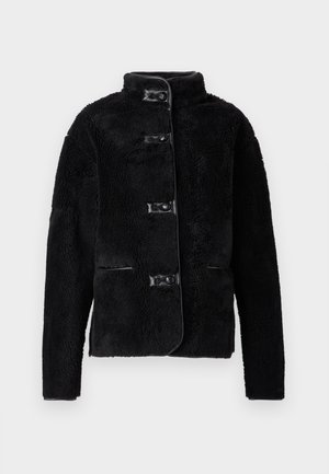 Schwarze Fleecejacke mit hochgeschlossenem Kragen, durchgehender Knopfleiste vorne und zwei Seitentaschen. Verfügt über eine weiche Textur und glatte, lederähnliche Akzente.