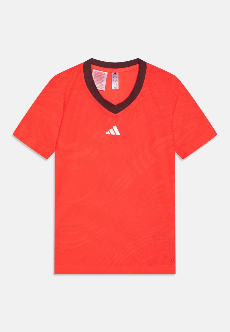 Rød atletisk t-skjorte med v-hals, brun krage og teksturerte mønstre. Har en hvit logo på venstre bryst. Korte ermer.