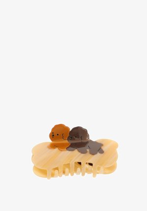 Haarclip van beige plastic, gevormd als een wolk met twee cartoonachtige hondenkoppen in lichtbruin en donkerbruin. Geribbelde textuur en tanden.
