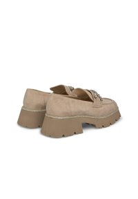 Beige suède platform schoenen met een chunky zool, verfraaid met metallic afwerking en decoratieve gespdetails aan de voorkant.