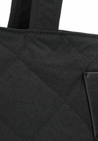 Bolsa tote de tela negra acolchada con asas resistentes, que presenta un acento de cuero negro suave y costuras visibles en un patrón de diamante.