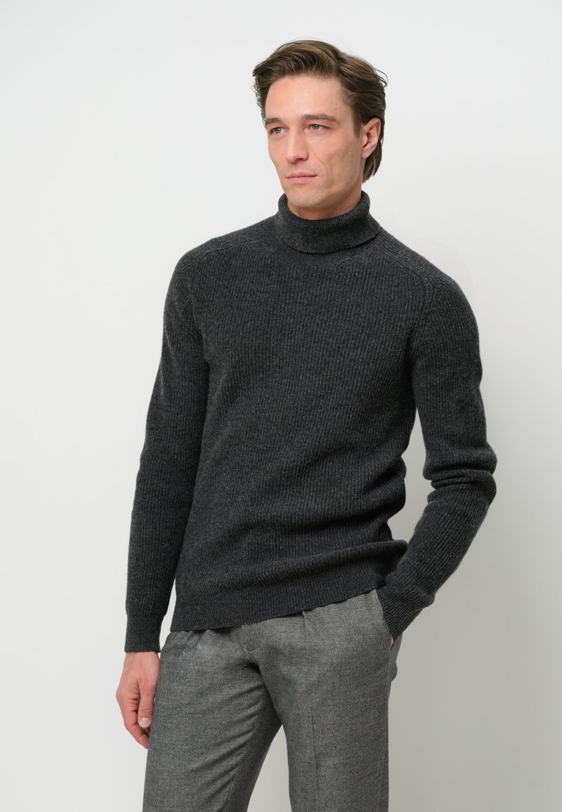 Dunkelgrauer, gerippter Rollkragenpullover aus strukturiertem Strickmaterial, kombiniert mit hellgrauen, maßgeschneiderten Hosen. Einfaches und modernes Design.