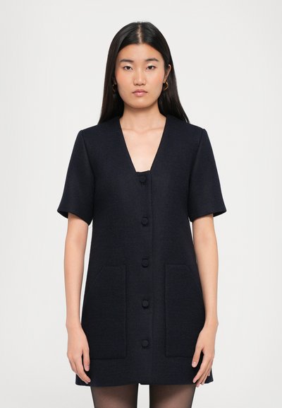 Rochie bleu marin cu mânecă scurtă, decolteu în V, cu nasturi pe față și două buzunare frontale. Textură netedă; design ajustat cu o siluetă conică.