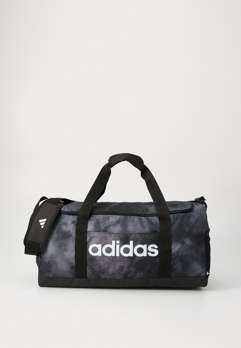 Čierna a sivá taška Adidas s vrchnými úchytmi a ramenným popruhom, so veľkým bielym logom Adidas na prednej vrecku.