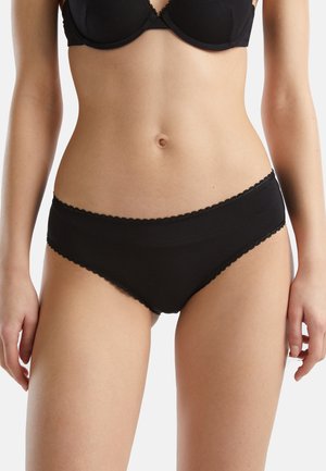 Braguitas de algodón negras con una textura suave, diseño de talle medio y bordes festoneados. Sin patrones visibles ni detalles adicionales de herrajes.